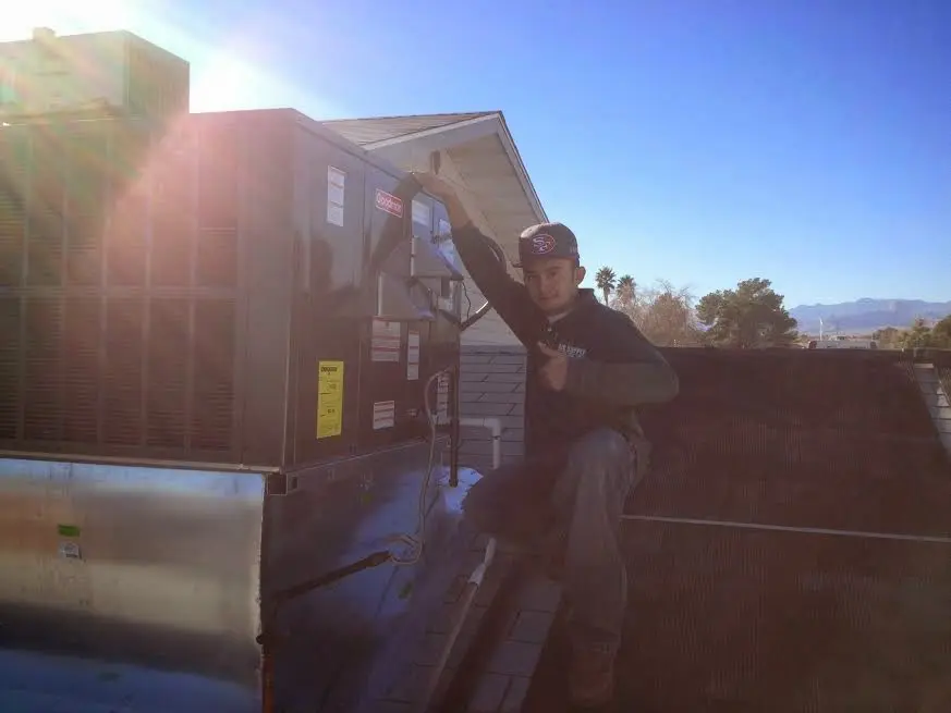 HVAC technician performing Boiler Repair on a rooftop unit in Bay City